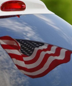 A photo of an American flag reflecting in an emergency vehicle windshield.