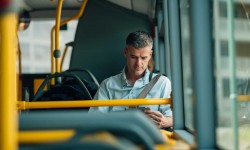 A photo of a gentleman reading in a propane powered bus.